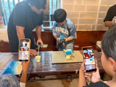 子どもがレジンアートを楽しむ姿を写真に残す家族