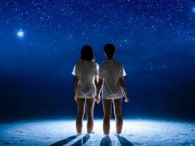 星空が広がる夜の海に浮かぶマーメイド姿の女性