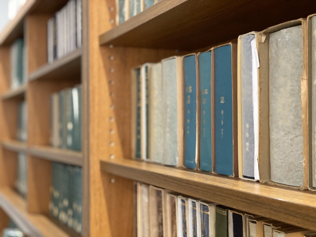 木の本棚に並ぶ専門書で知識を深める