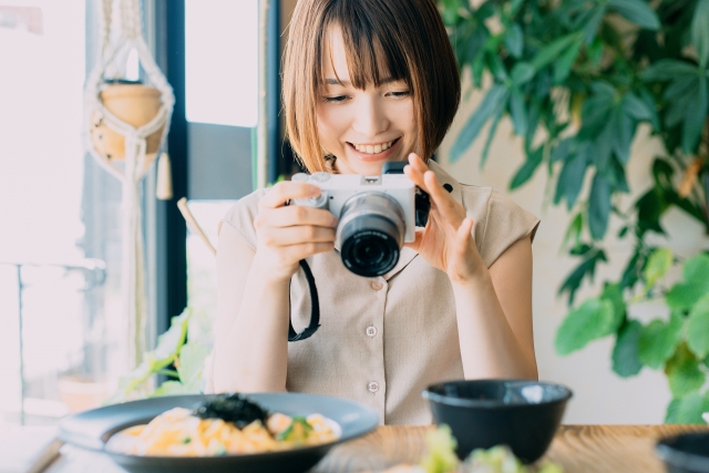 カフェで料理を撮影する女性